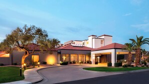 A modern hotel with a curved driveway, large windows, and a red-tiled roof. - Courtyard by Marriott Phoenix Airport (Phoenix)