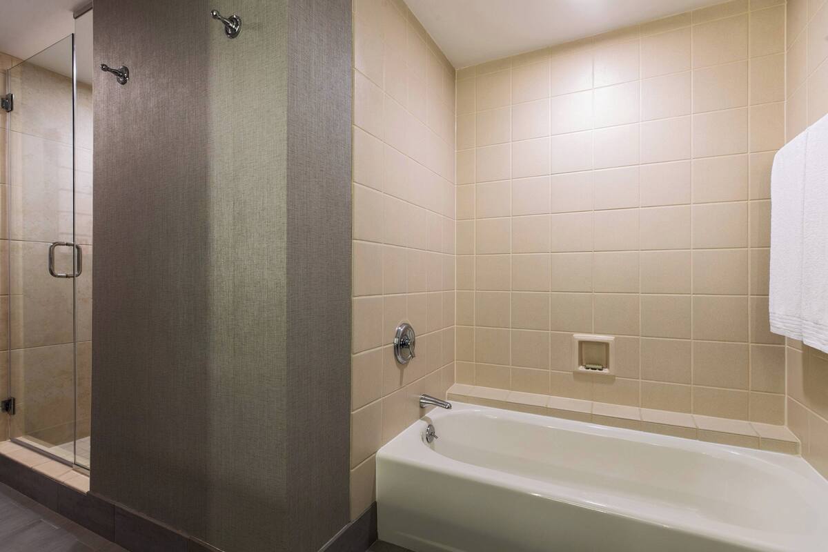 Une salle de bain avec une baignoire, un espace douche et un porte-serviettes.