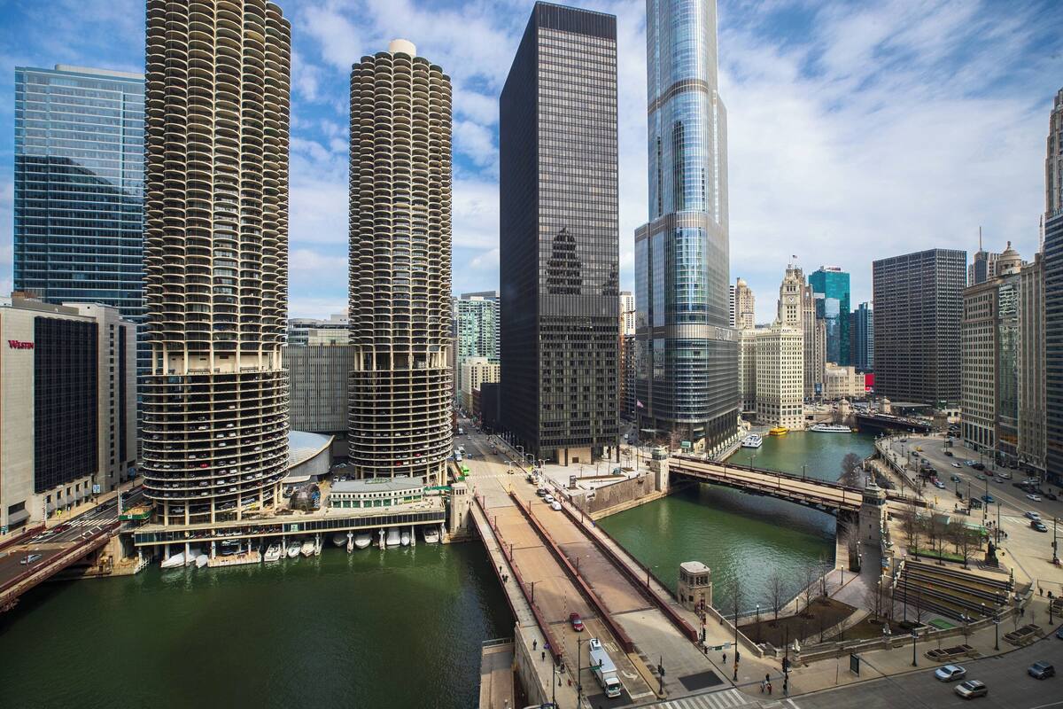 Une vue urbaine avec des gratte-ciel modernes, une rivière et un pont.