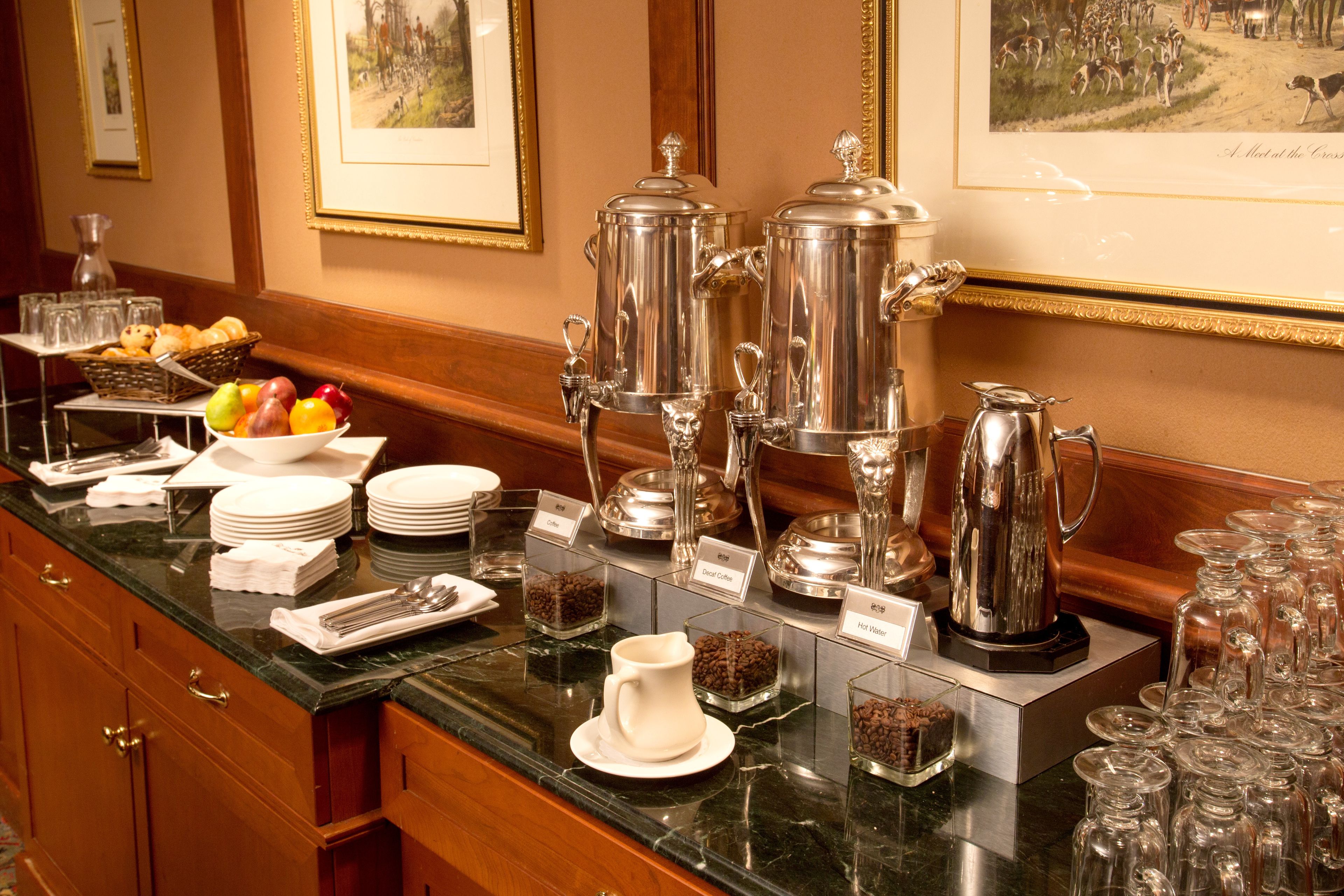 A buffet setup with various food and drink options, including coffee and hot water.
