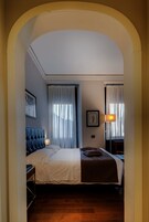 Una camera d'albergo con un letto, un comodino, una lampada e un quadro appeso al muro.
