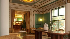 A lobby with a marble floor, a reception desk, and a bar area.