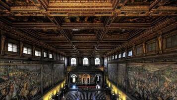 Een rijk gedecoreerd interieur met hoge plafonds, gedetailleerde fresco's en een centrale gang naar een altaar.