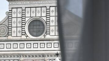 Un bâtiment doté d’une grande fenêtre circulaire au centre, d’une entrée imposante surmontée d’une arche et d’une haute flèche en arrière-plan.