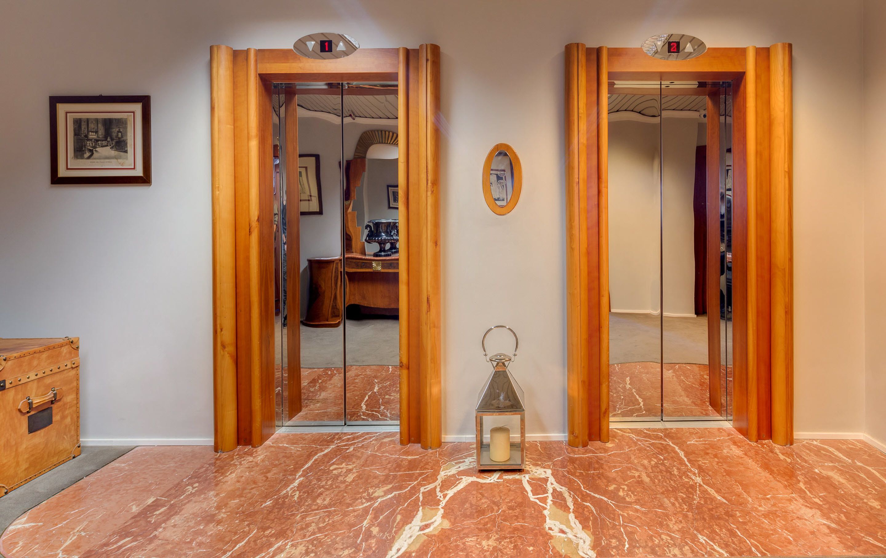A hallway with two wooden doors, each marked with a number. A small lantern is placed on the floor.