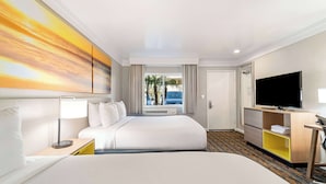 Habitación de hotel con una cama grande, televisión, escritorio y un cuadro en la pared.