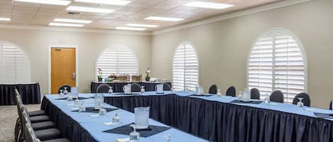 A conference room with a long table, chairs, and a podium.