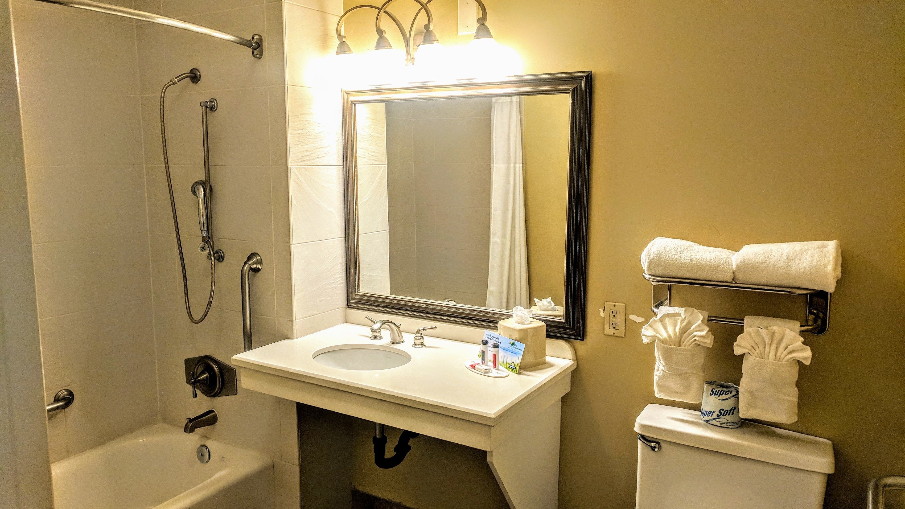 A bathroom with a bathtub, a sink, a toilet, and a towel rack.