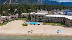 A resort with a pool, beach, and mountain views.
