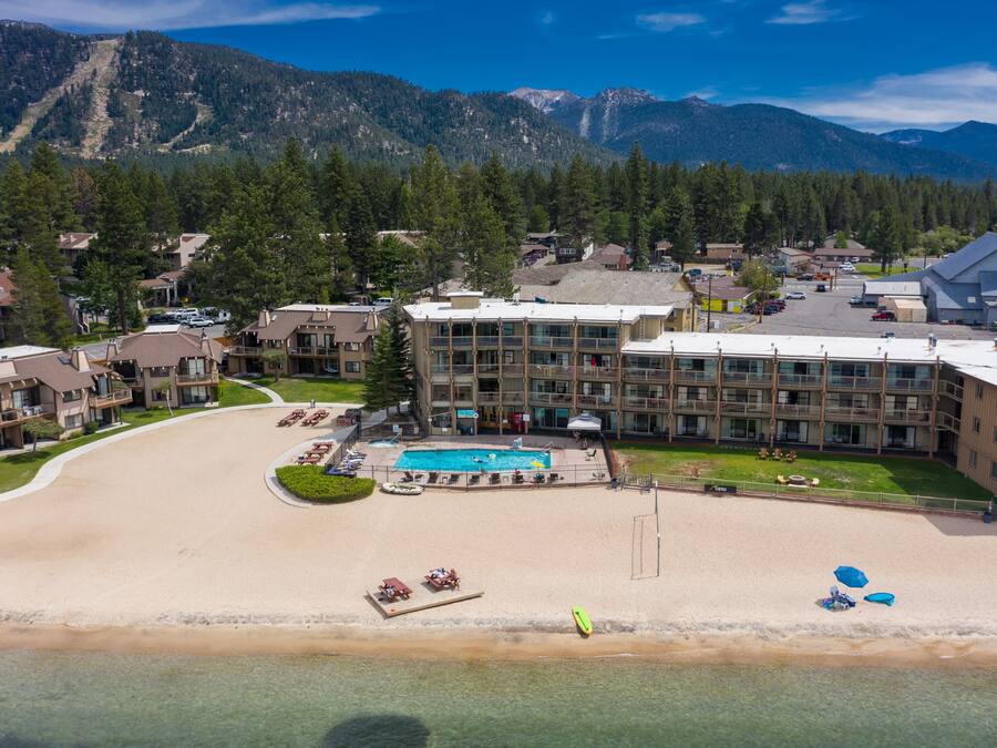 A resort with a pool, beach, and mountain views.