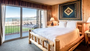 A large bed with a view of the sea through a sliding glass door.