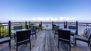 Une terrasse avec des sièges et une vue sur la mer.