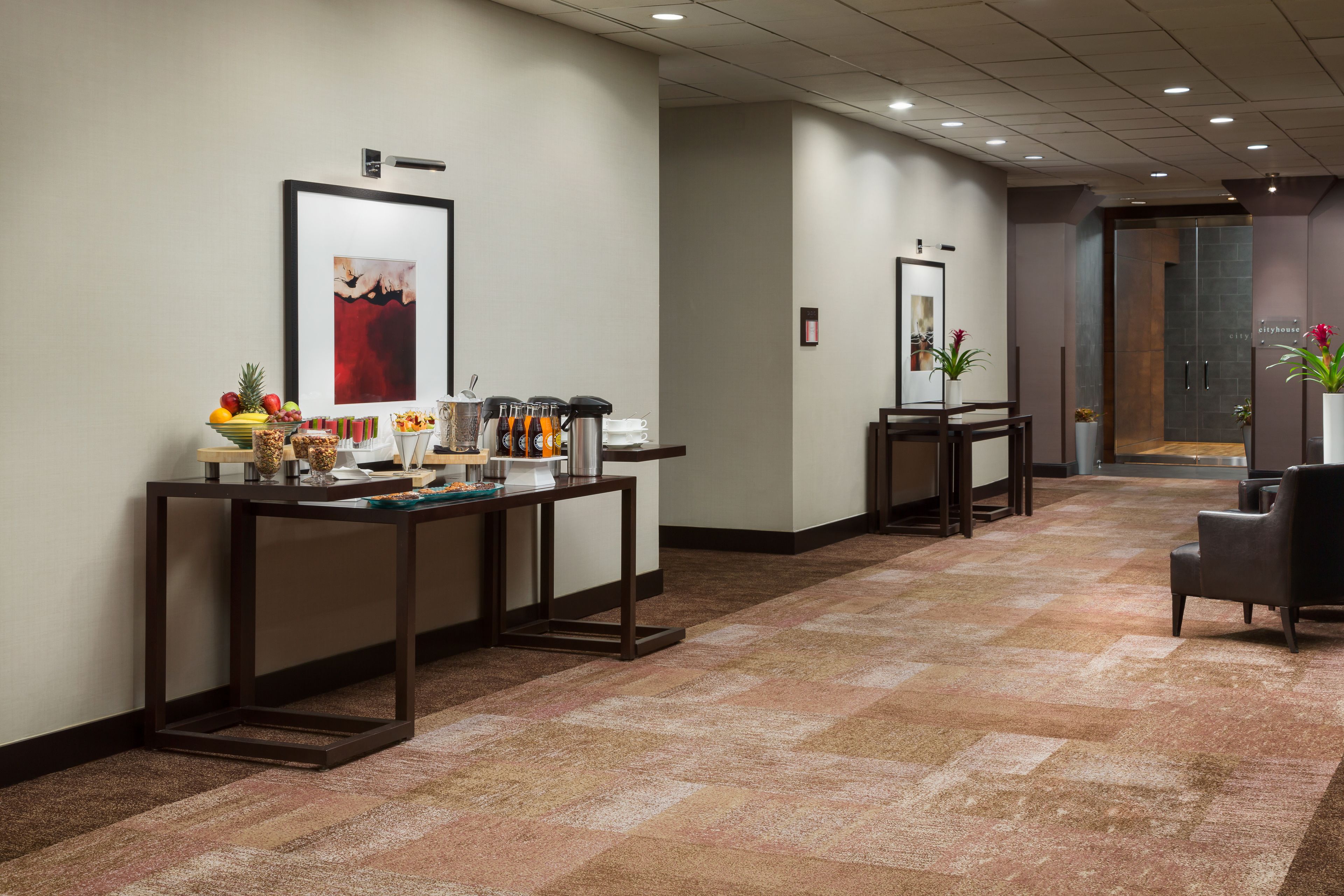 A reception area with a coffee station, framed artwork, and a seating area.