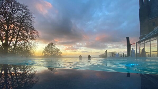 Una piscina cubierta, una piscina al aire libre, tumbonas