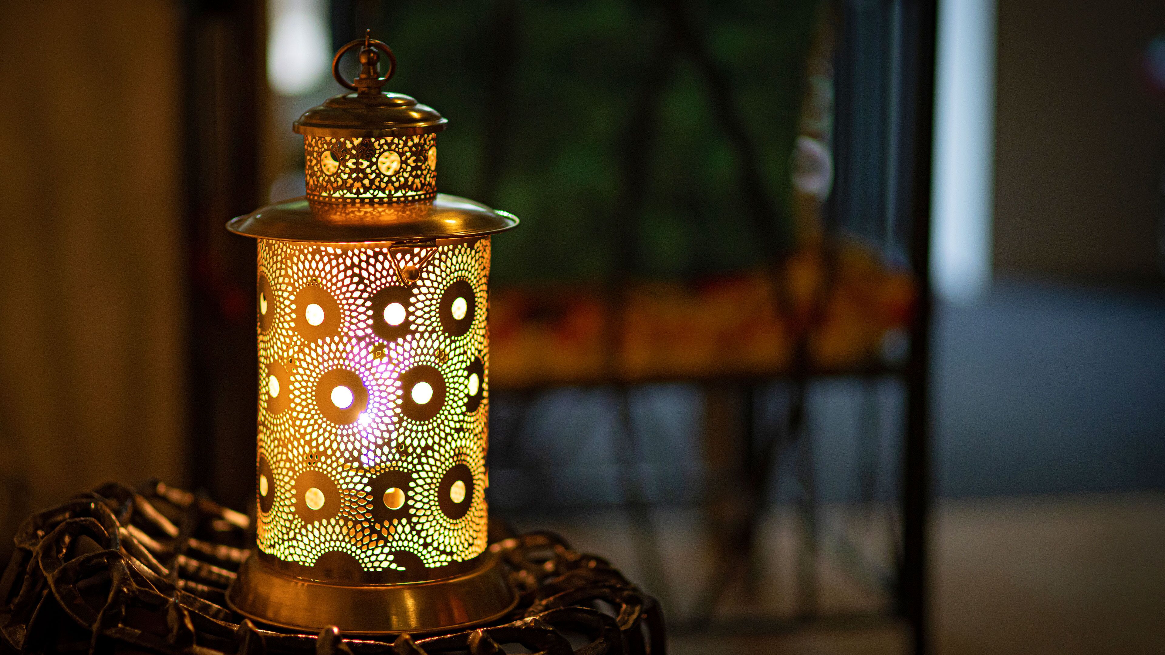 A decorative lantern with a patterned design, placed on a stand.