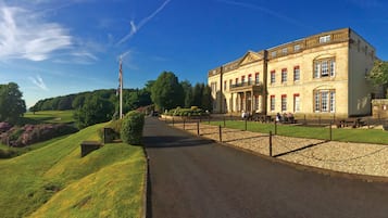 A historic building with a paved pathway leading to a seating area.