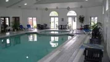 Una piscina techada, sillones reclinables de piscina
