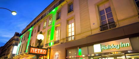 Un edificio con il cartello 'Holiday Inn', un cartello 'METRO' e un lampione.