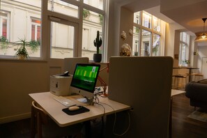 Un espace de bureau moderne, doté d’un bureau, d’un ordinateur et offrant une vue sur la rue grâce à de grandes fenêtres.