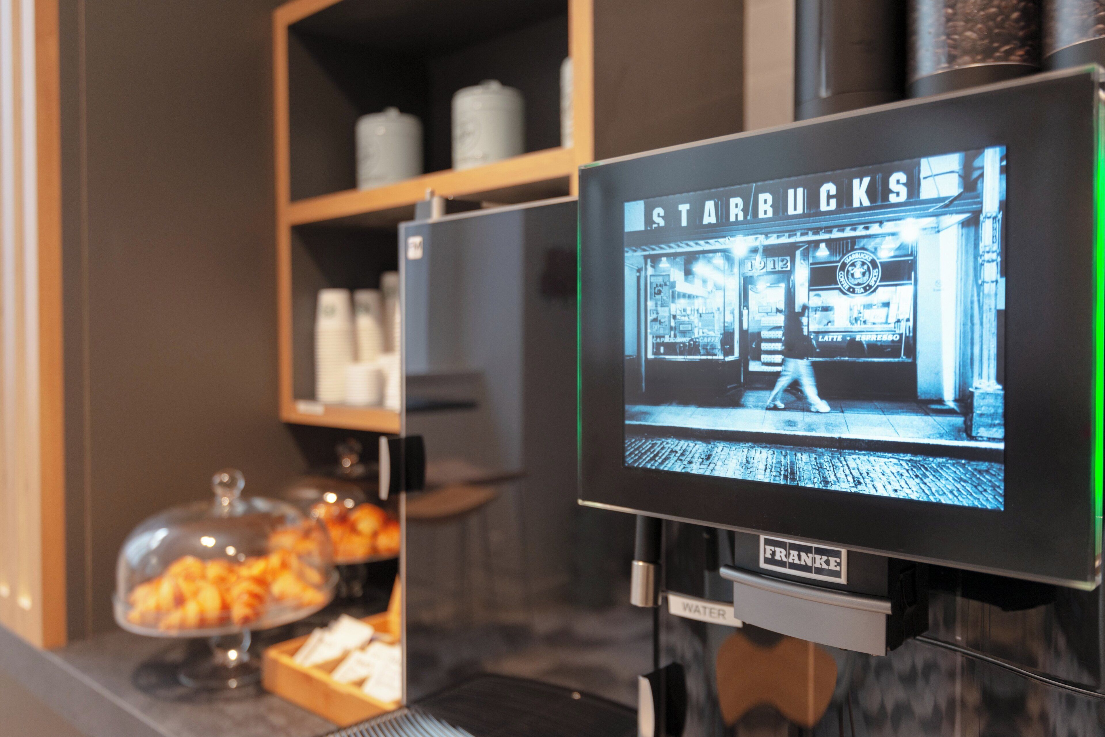Una máquina de café con una pantalla de Starbucks y un dispensador de agua.