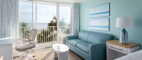 Une chambre d’hôtel avec un balcon, un canapé, un bureau et un lit.