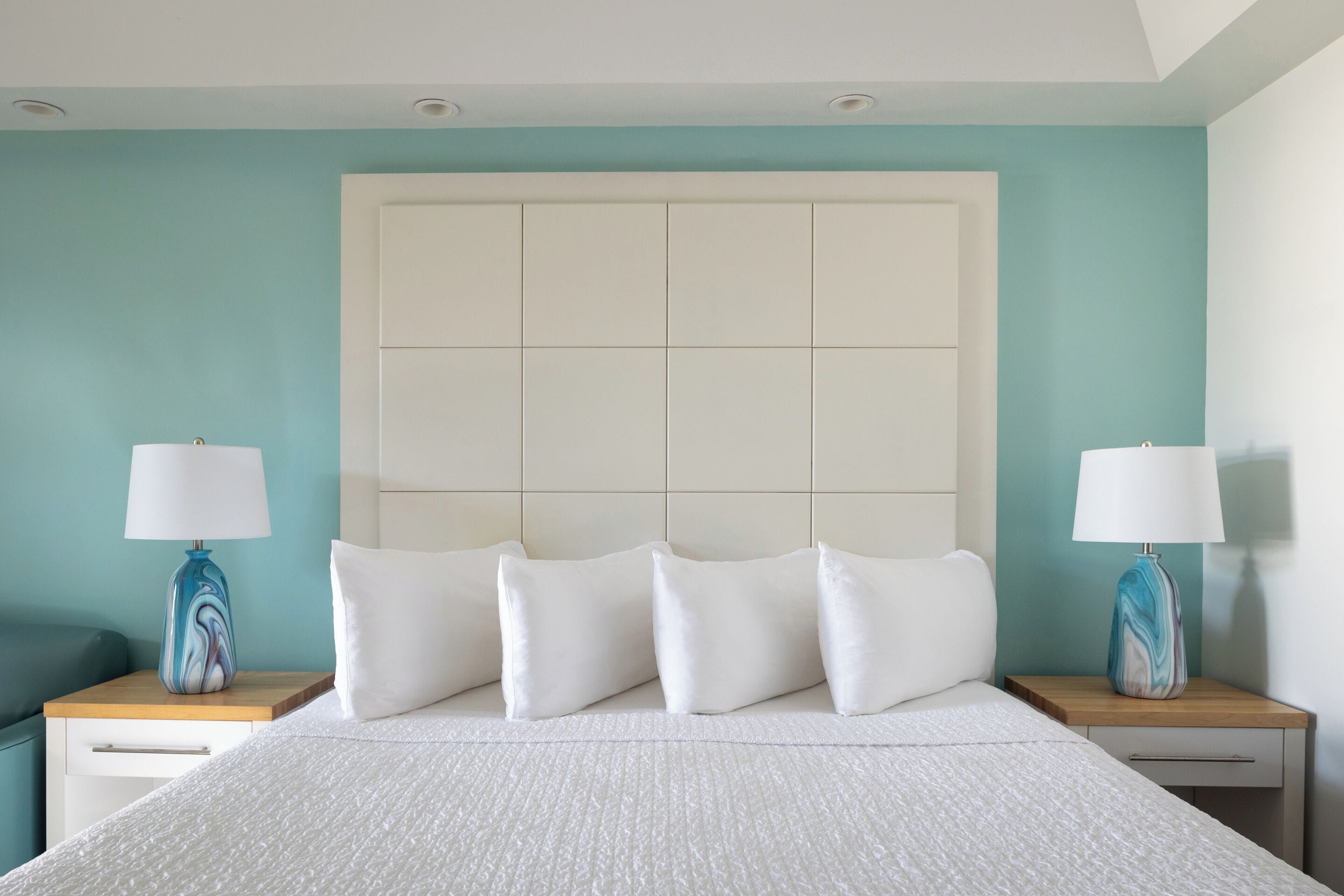 A hotel room with a large bed, two bedside tables, and a headboard.