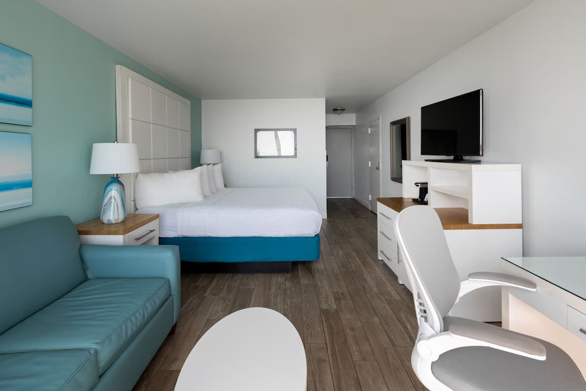 Une chambre d’hôtel moderne équipée d’un lit, d’un canapé, d’un bureau et d’une télévision.