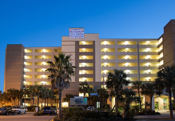 A multi-story hotel with a prominent 'TIDES' sign, multiple balconies, and a parking area with several cars. - Tides Folly Beach, Charleston's Oceanfront Hotel (Folly Beach)