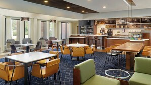 A modern hotel lobby with multiple seating areas, a bar, and a visible kitchen area. - Courtyard® by Marriott® Fort Lauderdale City of Plantation (Plantation)