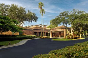 Stroll through the beautifully landscaped grounds, flanked by trees and a central entrance.
