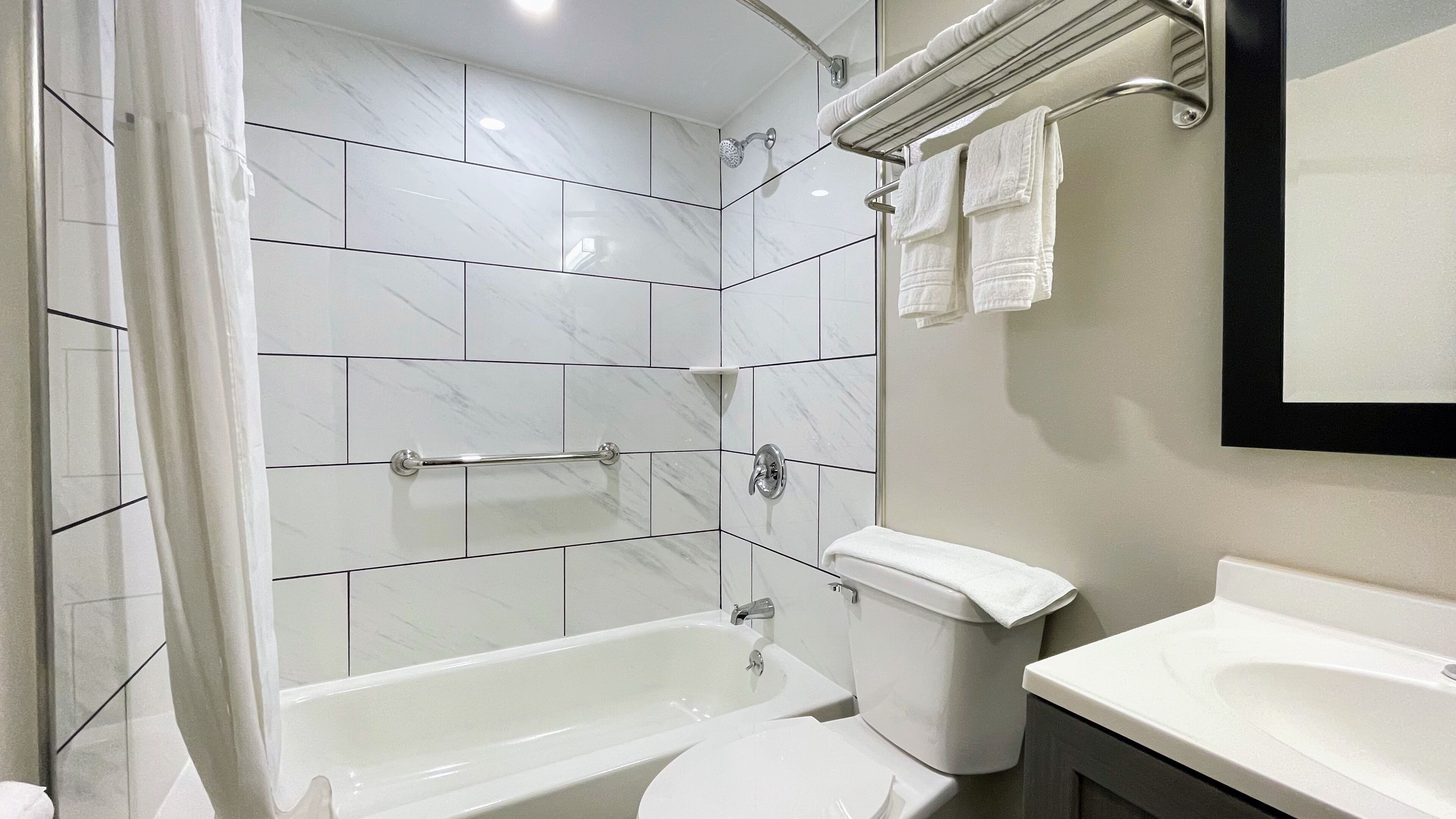 Ein modernes Badezimmer mit Badewanne, Toilette und Waschbecken.
