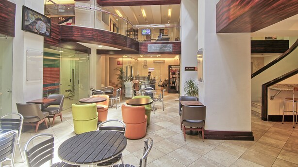 A multi-level indoor space with dining areas, a staircase, and a view of the lower level. - Balmoral Hotel San José CR, Historic District (San José)