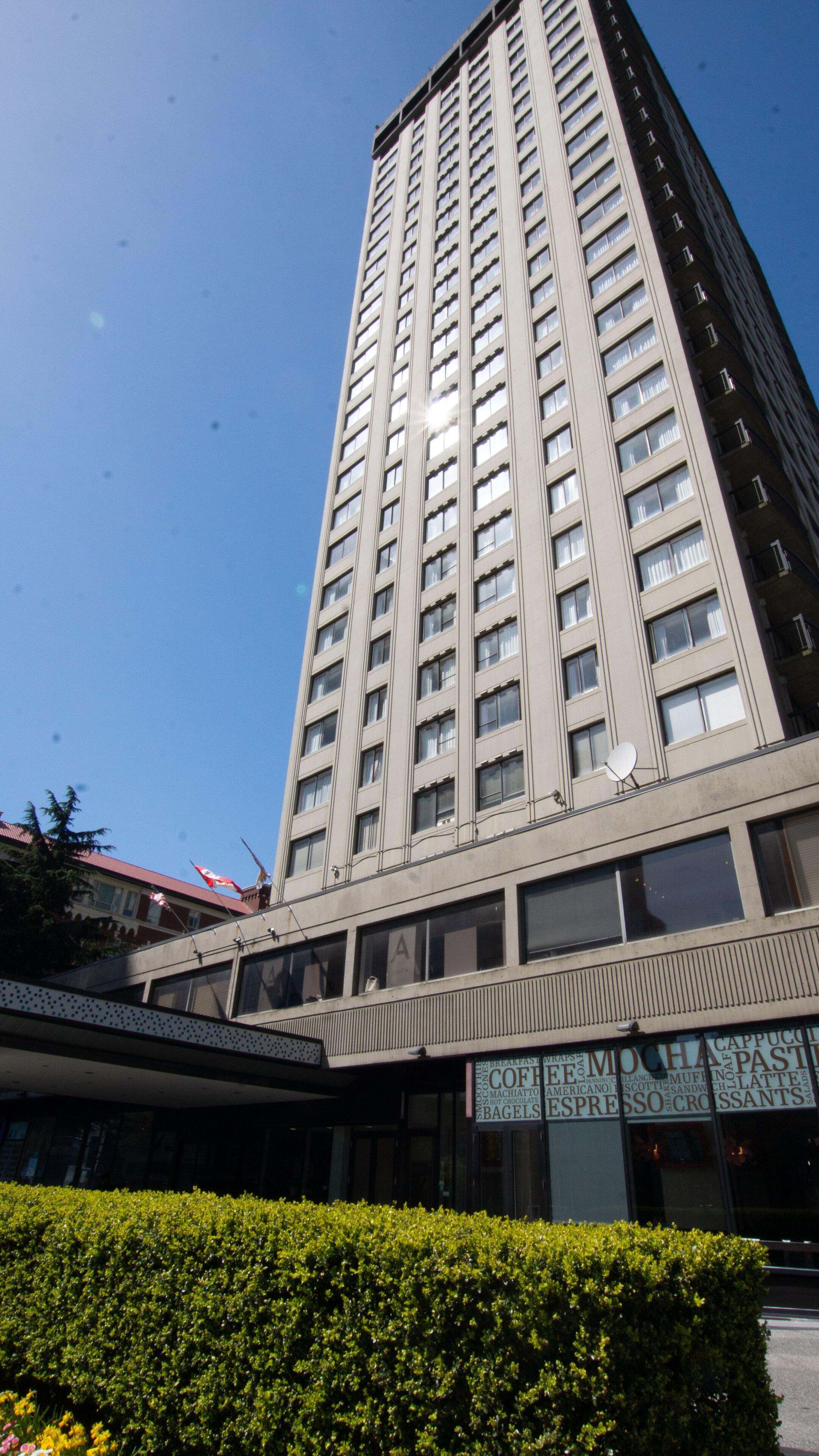A tall, modern building with a flat facade and numerous windows.