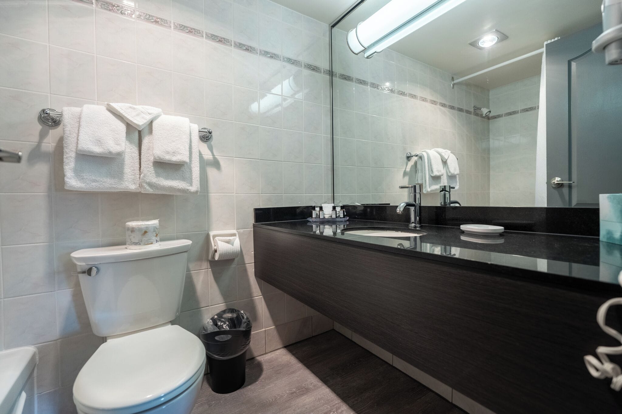 A modern bathroom with a toilet, sink, and mirror.