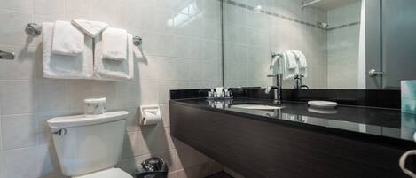 A modern bathroom with a toilet, sink, and mirror.