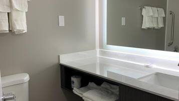 Een bad/douchecombinatie, een haardroger, handdoeken