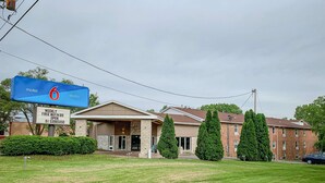 A motel with a large blue sign indicating it is number 6. - Motel 6 Rockford, IL (Rockford)