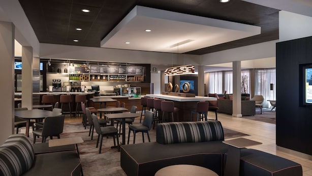 A modern lounge area with seating, a bar, and a coffee station. - Sonesta Select Phoenix Camelback (Phoenix)