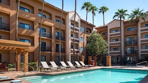 A hotel pool area with lounge chairs and a clear blue pool. - Sonesta Select Phoenix Camelback (Phoenix)