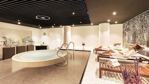 Un spa moderno con hidromasaje, sillones de descanso y suelo de piedrecitas.