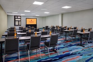 A conference room with tables, chairs, and a projector screen. - the Curtis Denver - a DoubleTree by Hilton Hotel (Denver)