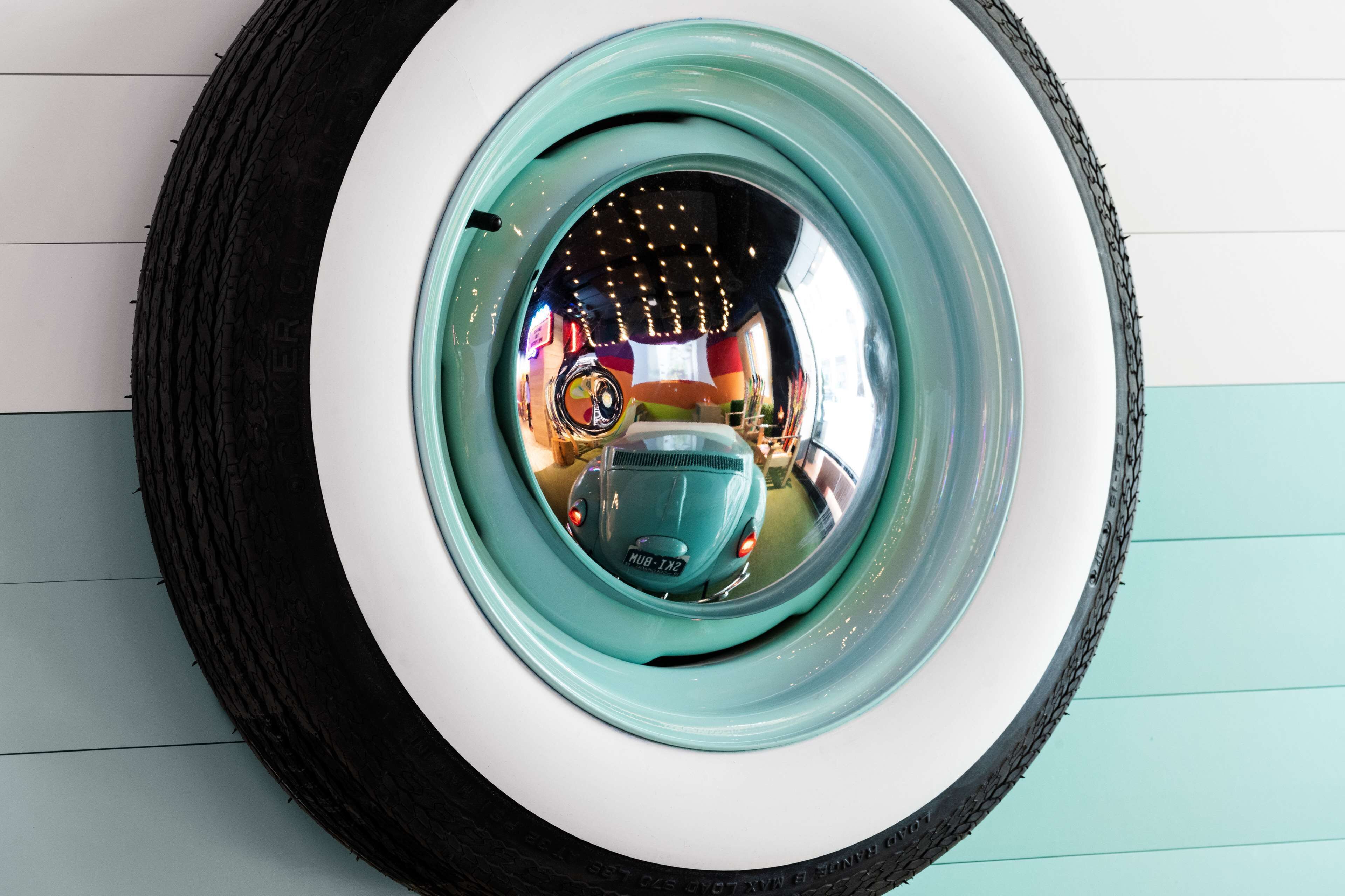 A circular object with a reflective surface, possibly a mirror or a decorative item, with a visible tire tread pattern and a label reading "MUB-132".