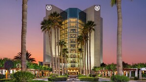 A modern hotel with a central atrium, surrounded by palm trees and well-maintained gardens. - Sheraton Jeddah Hotel - Saudi Brothers Commercial Company Branch (Jeddah)