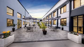 A courtyard with outdoor seating and potted plants.