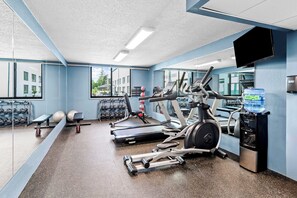 A gym with treadmills, elliptical machines, and free weights.