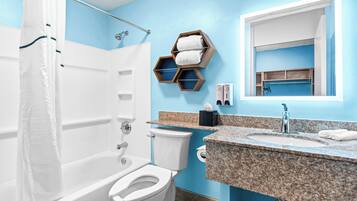 A bathroom with a bathtub, toilet, and sink. There is a shower curtain, a towel rack, and a mirror above the sink.