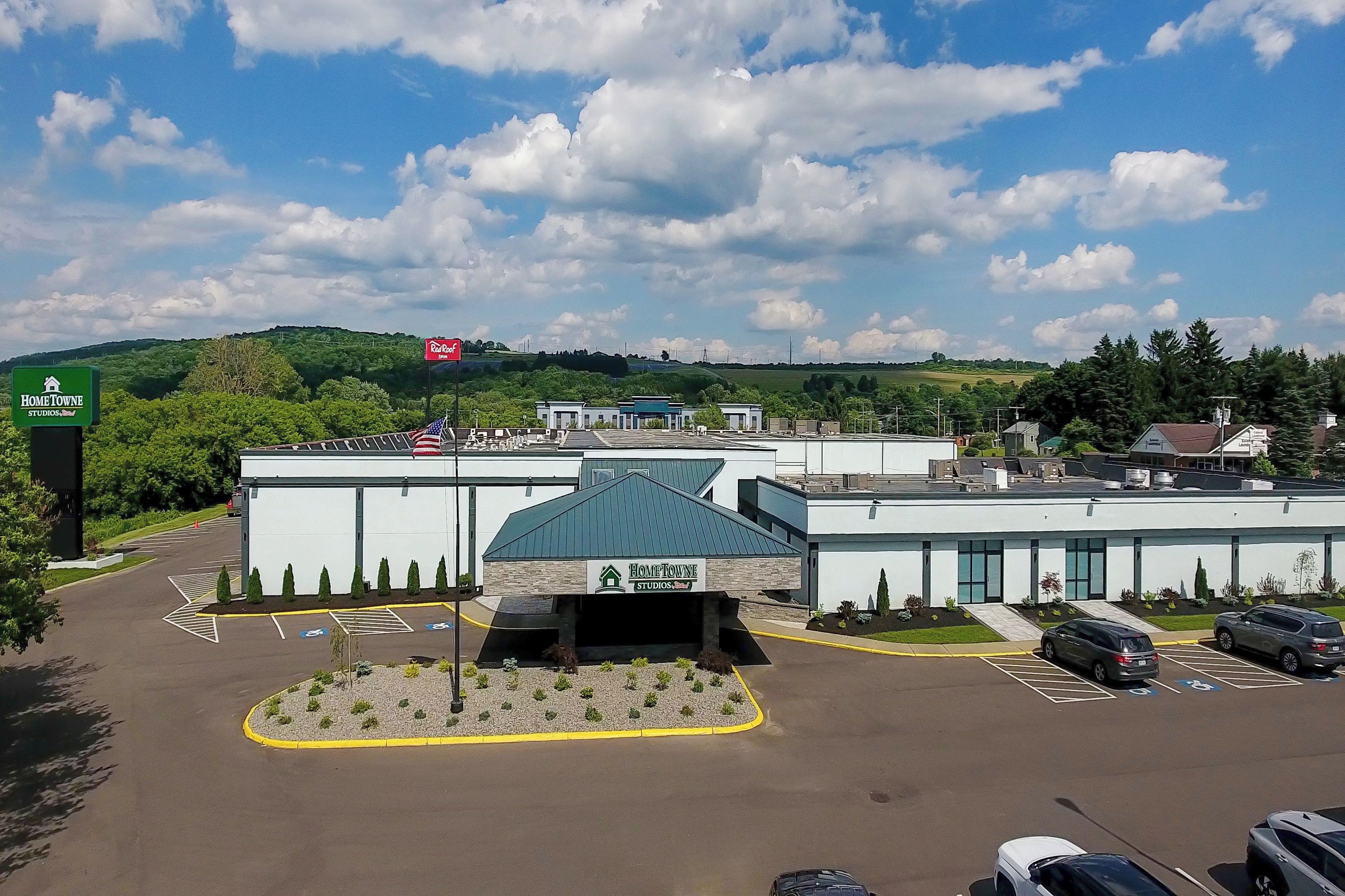 A commercial building with a parking lot, a covered entrance, and a sign for HomeTowne Studios.