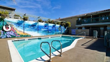 Una piscina al aire libre, sillones reclinables de piscina