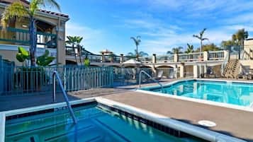 Una piscina al aire libre, sillones reclinables de piscina