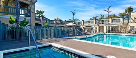 Een buitenzwembad, ligstoelen bij het zwembad